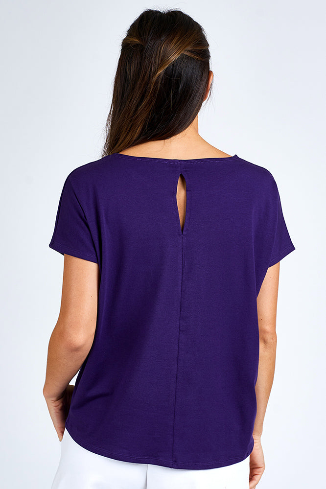 Woman wearing a purple short sleeve top.