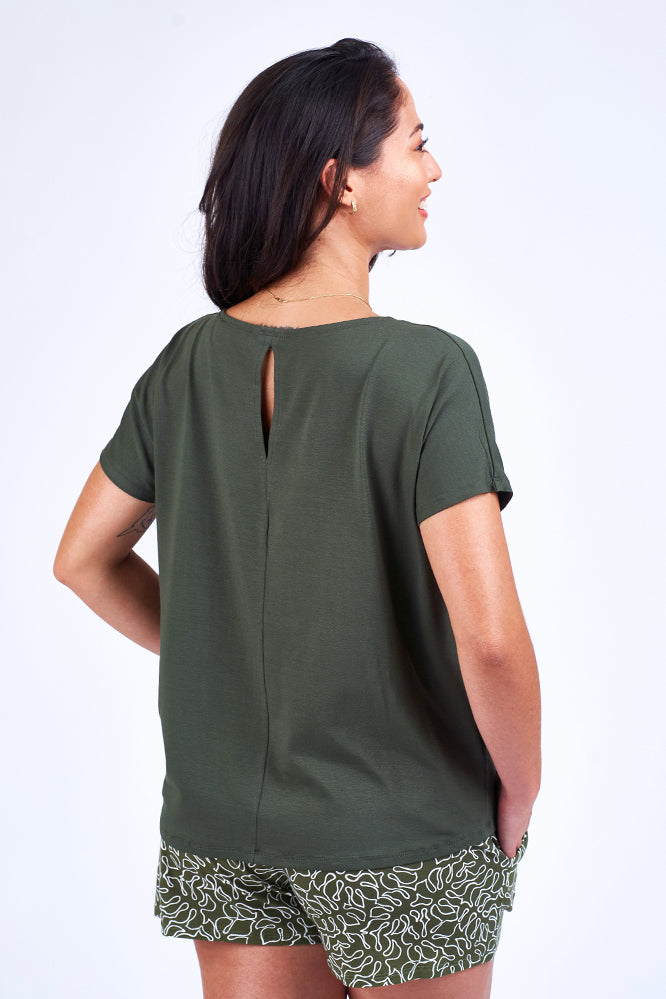 Woman wearing green print short and green top.
