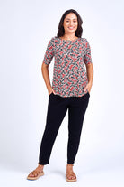 Woman wearing black pant and print top.