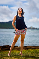 Woman wearing pink print short and black tank top.